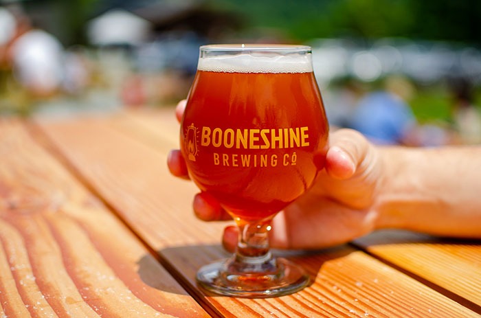 An Amber Lagar on a picnic table form Booneshine Brewing Company