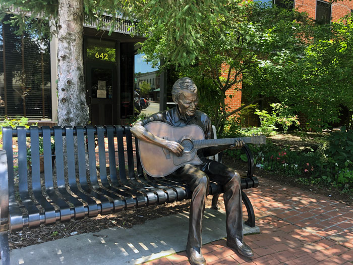 a statue of Doc Watson on a bench in Boone NC