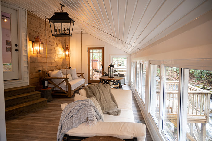 beautiful sunroom with a deck, couch, and a table at Cabin on the Cascades